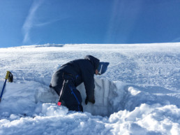 Off piste safety lesson looking at a snow profile in a snow pit